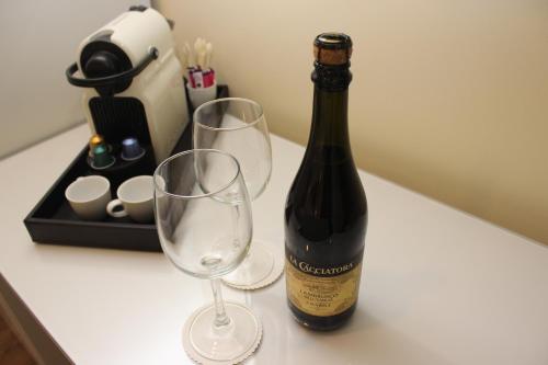 a bottle of wine and two wine glasses on a counter at Idelson Hotel in Tel Aviv