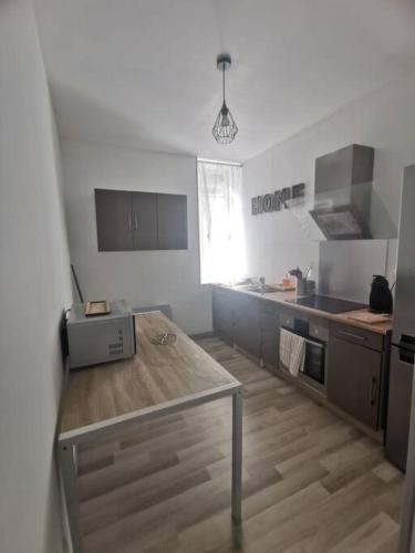 - une cuisine avec une table au milieu d'une pièce dans l'établissement Appartement, à Saint-Bonnet-le-Château