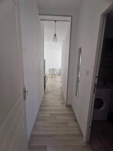 un couloir menant à une chambre avec une table dans l'établissement Appartement, à Saint-Bonnet-le-Château