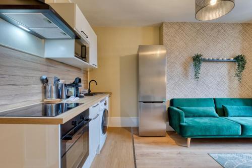 - une cuisine avec un canapé vert dans une chambre dans l'établissement Mathilde Appartement proche Clinique Mathilde, à Rouen