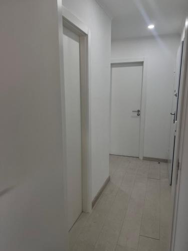 an empty hallway with white walls and doors at Orquídea in Cacém