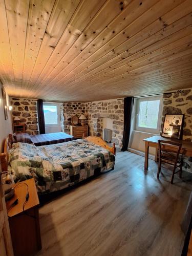 une chambre avec un lit et un plafond en bois dans l'établissement Les chambres du Ray-Pic, à Péreyres