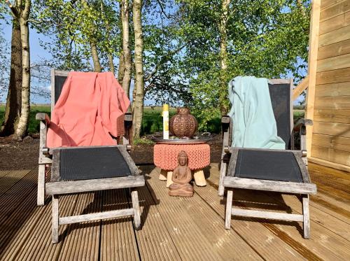 two chairs and a table on a wooden deck at Kampari in Delfstrahuizen