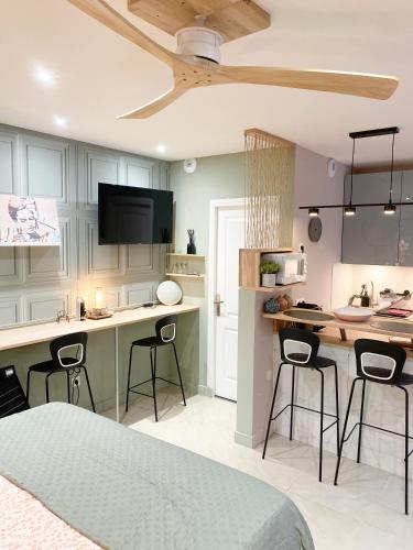 une cuisine avec un comptoir et deux tabourets de bar dans l'établissement Studio chic et romantique Lyon, à Villeurbanne