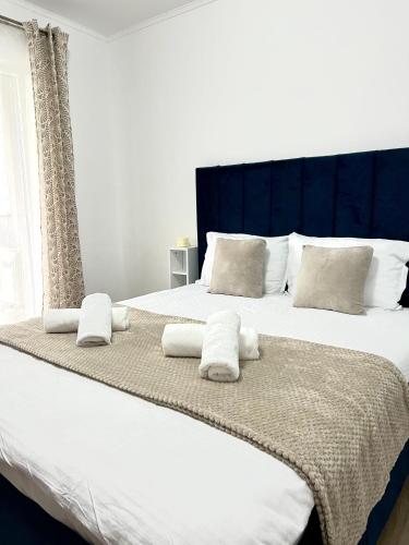 a bedroom with two beds with white sheets and pillows at Rainbow Apartments in Floreşti