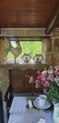 a table with a vase of flowers and a bird on a window at Il rifugio del duca in Solopaca