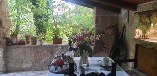 a table with a vase of flowers on a stone wall at Il rifugio del duca in Solopaca