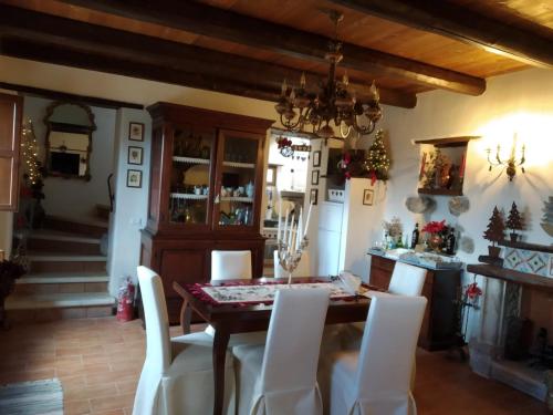 a dining room with a table and white chairs at Il rifugio del duca in Solopaca