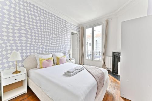 une chambre blanche avec un lit blanc et une fenêtre dans l'établissement Appartement charmant et coloré Montparnasse - II, à Paris
