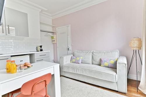 un salon blanc avec un canapé et une table dans l'établissement Appartement charmant et coloré Montparnasse - II, à Paris