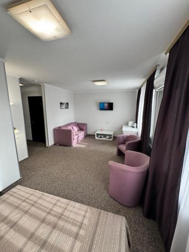 a living room with purple chairs and a couch at Dnepropetrovsk Hotel in Dnipro