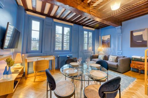 - un salon avec des murs bleus, une table et des chaises dans l'établissement Les Loges Saint Éloi Somptueux F4 pour 7 personnes, à Rouen