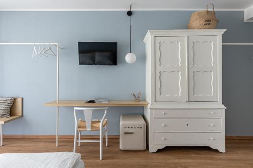 a bedroom with a desk and a white cabinet at Hotel Trento Alta in Sardagna