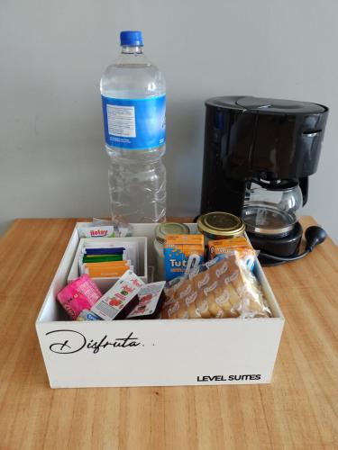 Eine Schachtel mit Essen und eine Flasche Wasser auf einem Tisch in der Unterkunft LEVEL SUITES una propuesta diferente in Bahía Blanca
