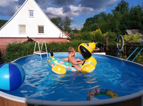 a young child is riding on an inflatable at Penzion Kučera apartmán in Dolní Moravice