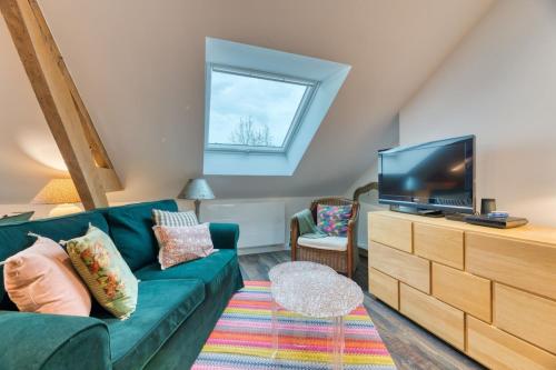 - un salon avec un canapé vert et une télévision dans l'établissement Martin Bel F2 confortable, à Rouen