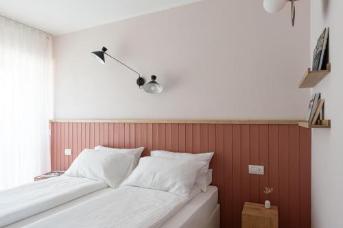 a bedroom with a bed with a red wall at Hotel Trento Alta in Sardagna