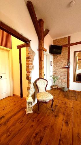 a living room with a chair and a brick wall at Mohrenbrunnen Apartments in Eisenberg