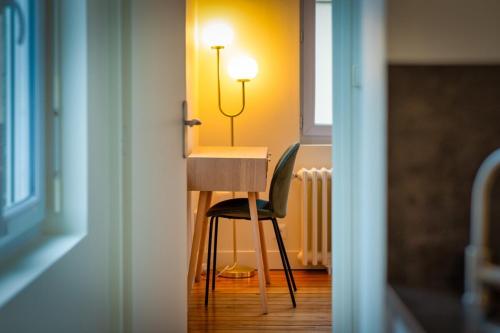 una scrivania con sedia e una lampada in una stanza di Emma Mignon F2 proche de la gare a Rouen