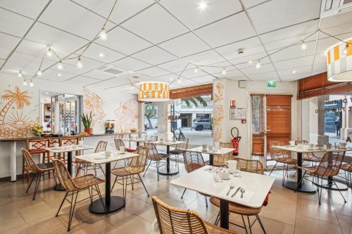 Hôtel AKENA Biarritz - Grande plage في بياريتز: غرفة طعام مع طاولات وكراسي في مطعم