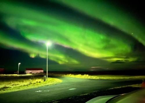 an image of a road with the green northern lights at Luk House in Gardur