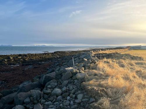 a group of rocks on a beach near the water at Luk House in Gardur