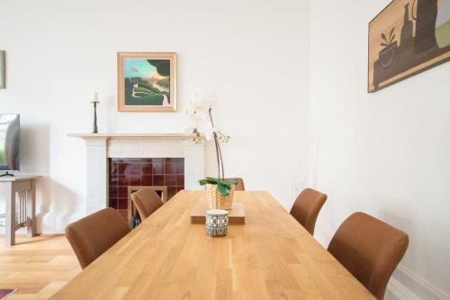 a dining room with a table with chairs and a fireplace at Stunning 3 Bed Flat in the Heart of the West End in Glasgow