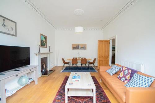 a living room with a couch and a table at Stunning 3 Bed Flat in the Heart of the West End in Glasgow