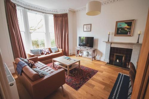 a living room with a couch and a fireplace at Stunning 3 Bed Flat in the Heart of the West End in Glasgow