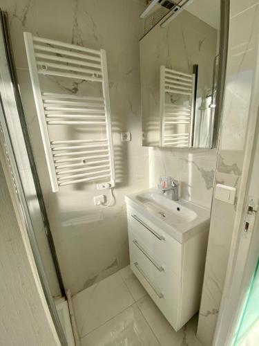 une salle de bain blanche avec un lavabo et un miroir dans l'établissement Château Saint Louis - Menton, à Menton