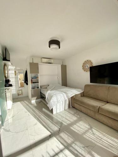 - une chambre blanche avec un lit et un canapé dans l'établissement Château Saint Louis - Menton, à Menton