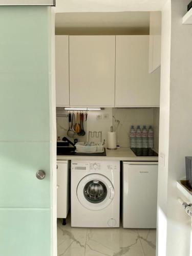 une cuisine blanche avec une machine à laver à l'intérieur dans l'établissement Château Saint Louis - Menton, à Menton