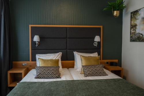 a bedroom with a large bed with two pillows at Hotel Restaurant Het Witte Huis in Olterterp