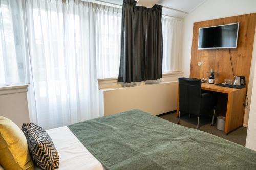 a hotel room with a bed and a desk with a computer at Hotel Restaurant Het Witte Huis in Olterterp