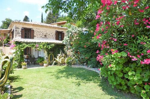 a garden with pink flowers and a house at Hoolit House in Vournikás