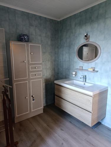 une salle de bain avec un lavabo et un miroir dans l'établissement Florélia Jurassienne, à Beauvoisin