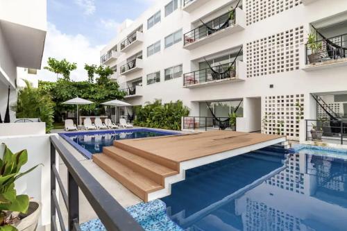 an apartment with a swimming pool and a building at Papaya Suites Diamante - Adults Only in Acapulco