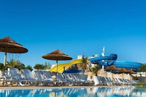 une piscine avec des chaises et un parc aquatique dans l'établissement Mobilhome confortable, spacieux et lumineux dans camping, aux Mathes