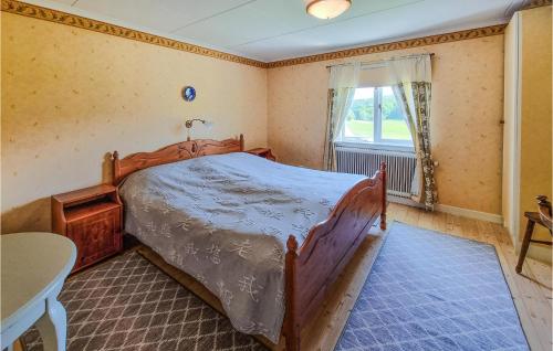 a bedroom with a wooden bed and a window at Awesome Home In Fjällbacka With Wifi in Fjällbacka