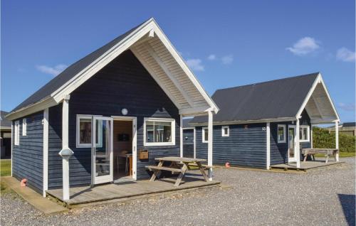 a blue house with a picnic table in front of it at Hytte 16 in Thyborøn