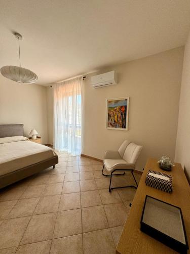 a bedroom with a bed and a desk and a chair at Casa Magenta Holiday in Galatro