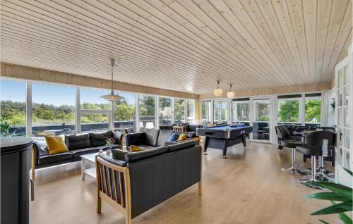 Habitación grande con sofás, mesas y ventanas. en Eight-Bedroom Holiday Home In Norre Nebel, en Nørre Nebel