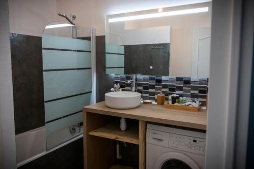 une salle de bain avec un lavabo et une machine à laver dans l'établissement Chez Marine, à Carnac