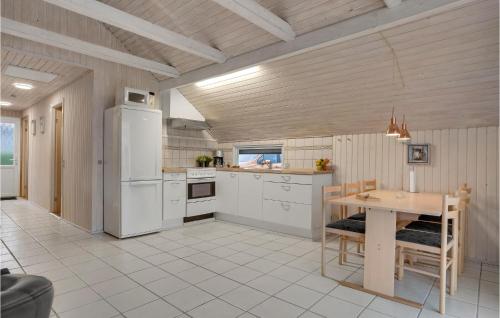 a kitchen with a table and a white refrigerator at Gorgeous Home In Hejls With Wifi in Hejls