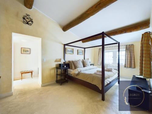 une chambre avec un lit à baldaquin dans une pièce dans l'établissement La carrière Saint Rémy de Provence, à Saint-Rémy-de-Provence