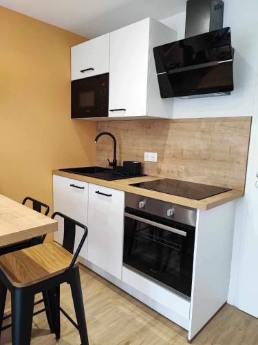 Il comprend une cuisine équipée d'une cuisinière, d'un évier et d'une table. dans l'établissement Studio 15, proche rue piétonne et plage, à Saint-Jean-de-Monts