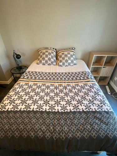 a bedroom with a large bed with two pillows at Maison proche de vichy in Saint-Rémy-en-Rollat