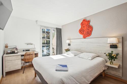 une chambre d'hôtel avec un lit et un bureau et un bureau dans l'établissement Hôtel AKENA Biarritz - Grande plage, à Biarritz