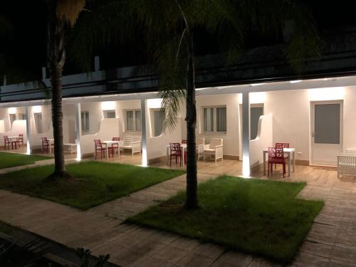 a patio with tables and chairs at night at Hotel Borina by Isola dei sapori in Foce Varano