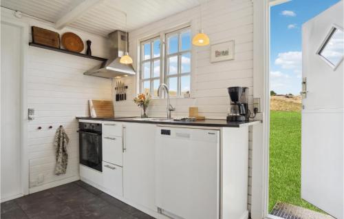 a kitchen with white cabinets and a stove at 3 Bedroom Amazing Home In Fanø in Fanø